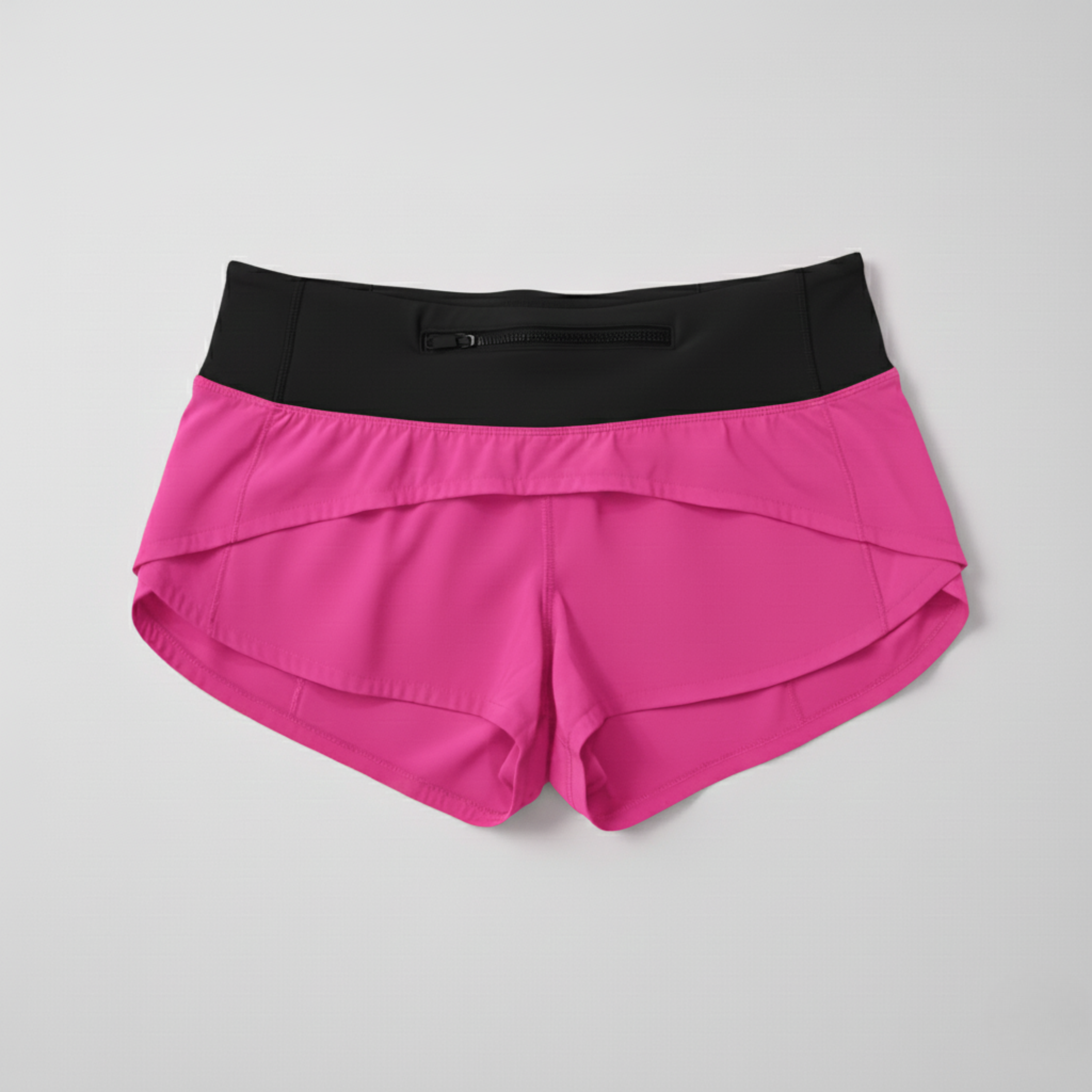 Back view of the Hot Pink low-rise cheer shorts showing the black zippered pocket on the waistband and the layered, split hem detail.